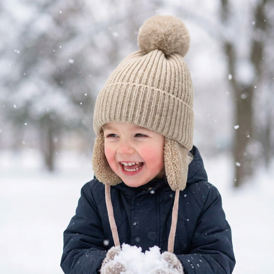 Child wearing a knit beanie with earflaps outdoors - lifestyle